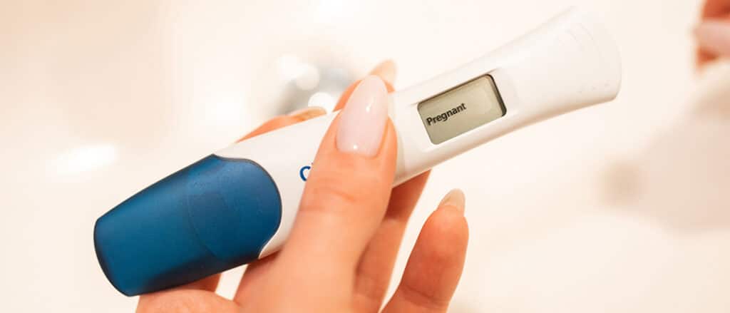 Een digitale zwangerschapstest dat het woord 'Pregnant' vermeldt.